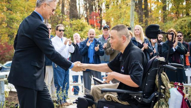 Gary Sinise shaking hands with a wounded veteran