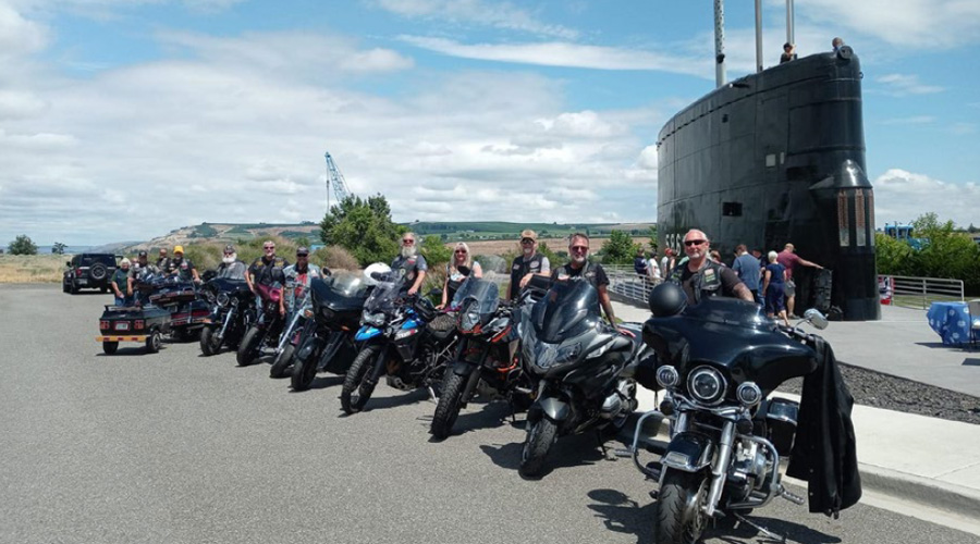 Member's bikes parked near a submarine monument